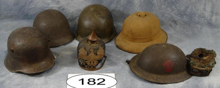 Group of four metal olive drab military helmets W W