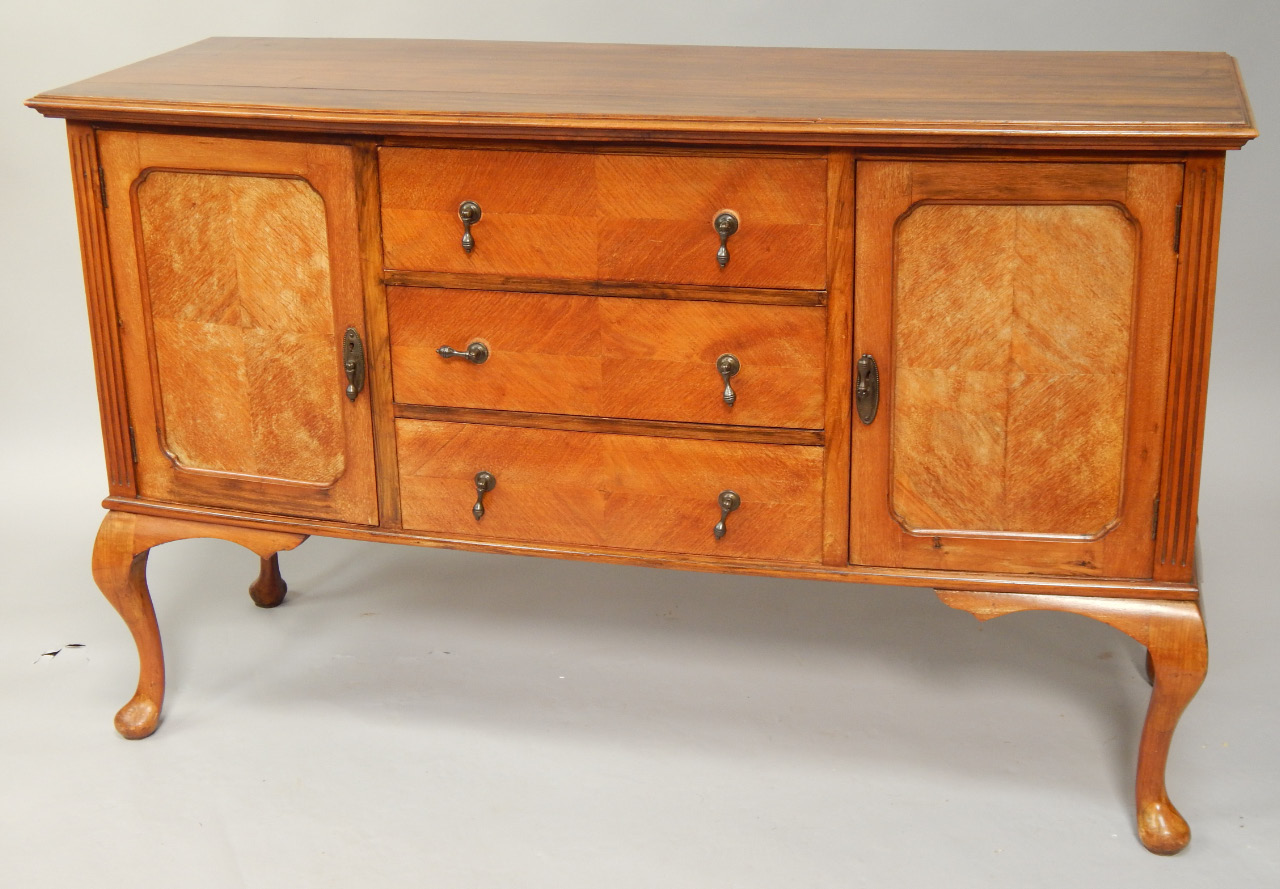 A George V walnut sideboard with slightly bowed front and