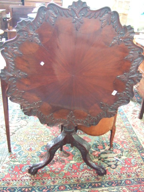 A George III style carved and radially veneered mahogany tilt