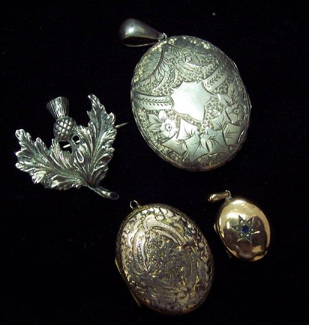 An engraved silver locket Birmingham hallmarks a silver thistle brooch