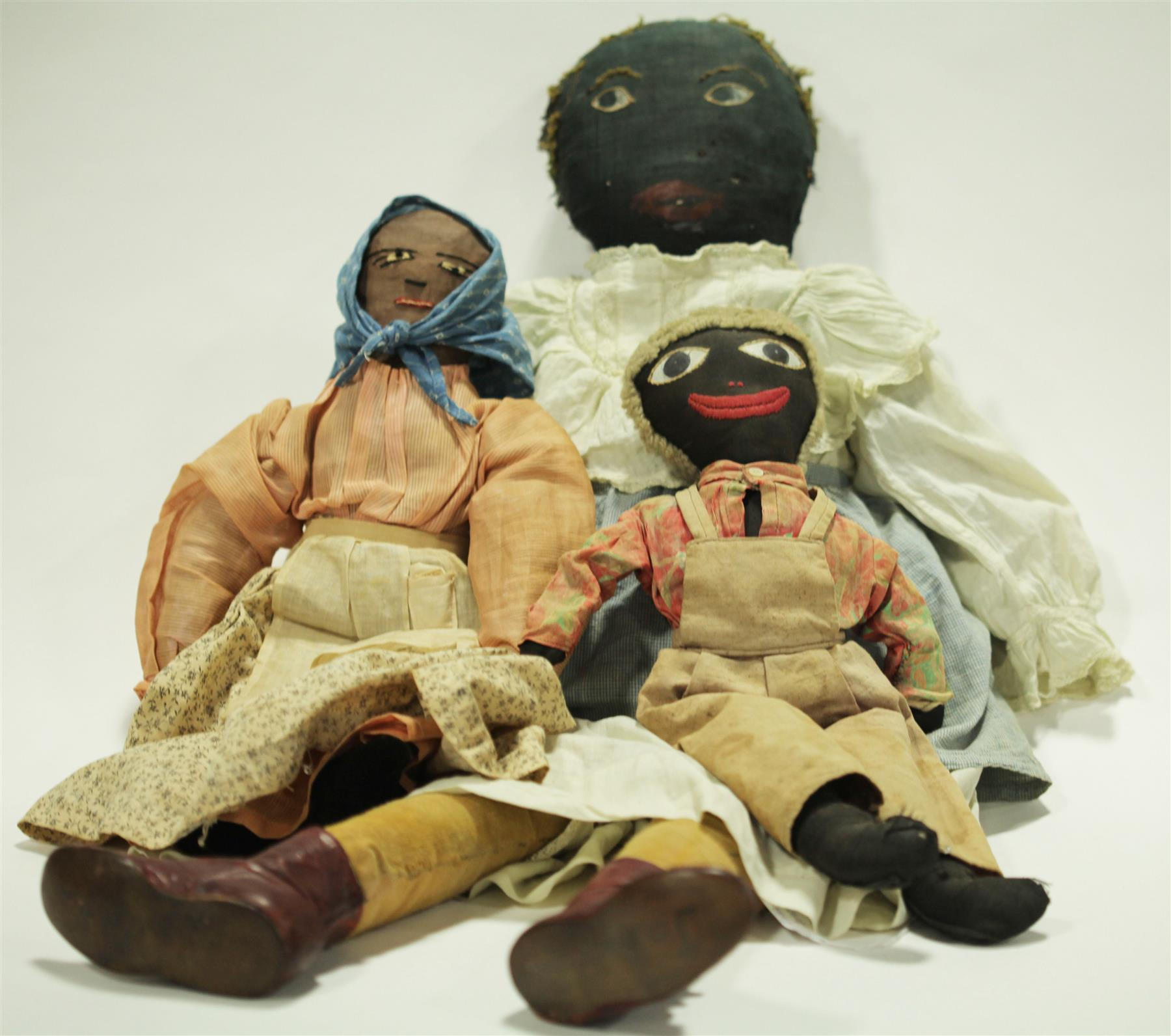 THREE BLACK CLOTH DOLLS WITH PAINTED AND STITCHED FEATURES Late