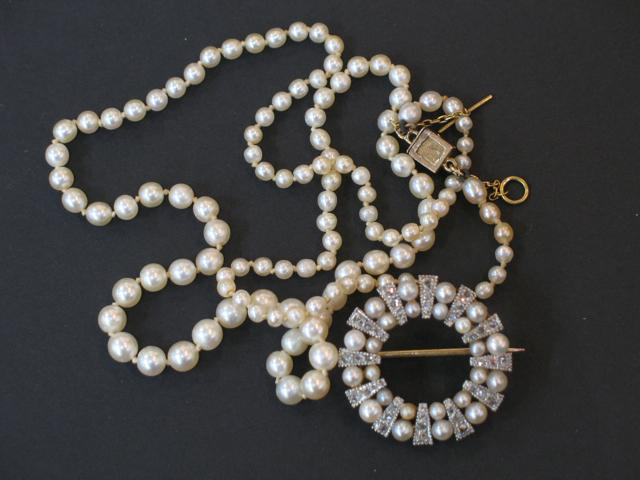 A SINGLE STRAND GRADUATED NATURAL PEARL NECKLACE with square diamond