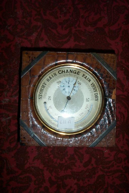 An Edwardian desktop barometer in a brass case incorporating a