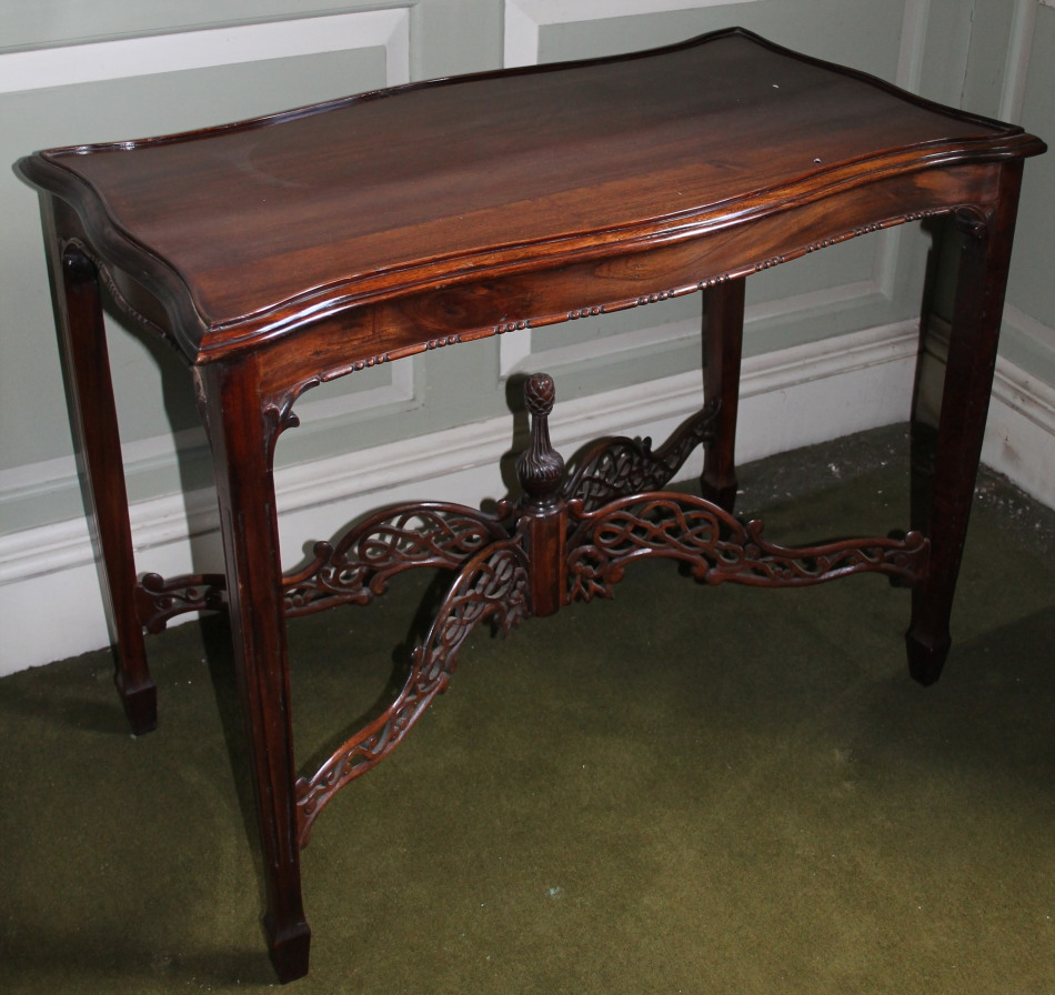 A modern mahogany table in Chippendale style the shaped top