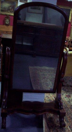 A Victorian mahogany arch top cheval glass with fluted scroll