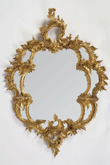 A ROCOCO STYLE GILT WALL MIRROR the cartouche shaped plate