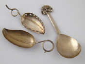 A leaf caddy spoon with tendril handle marked Sterling a