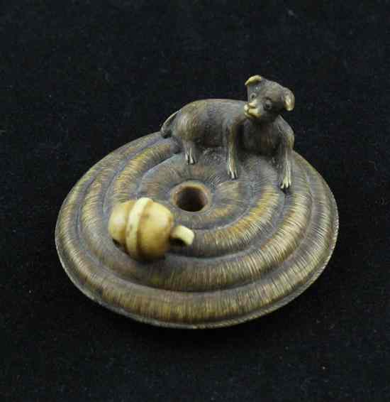 A Meiji period stained ivory netsuke carved as a puppy