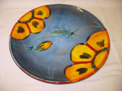 A POOLE POTTERY CHARGER of circular form painted with yellow