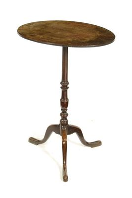 A mahogany tripod table the oval top on a slender