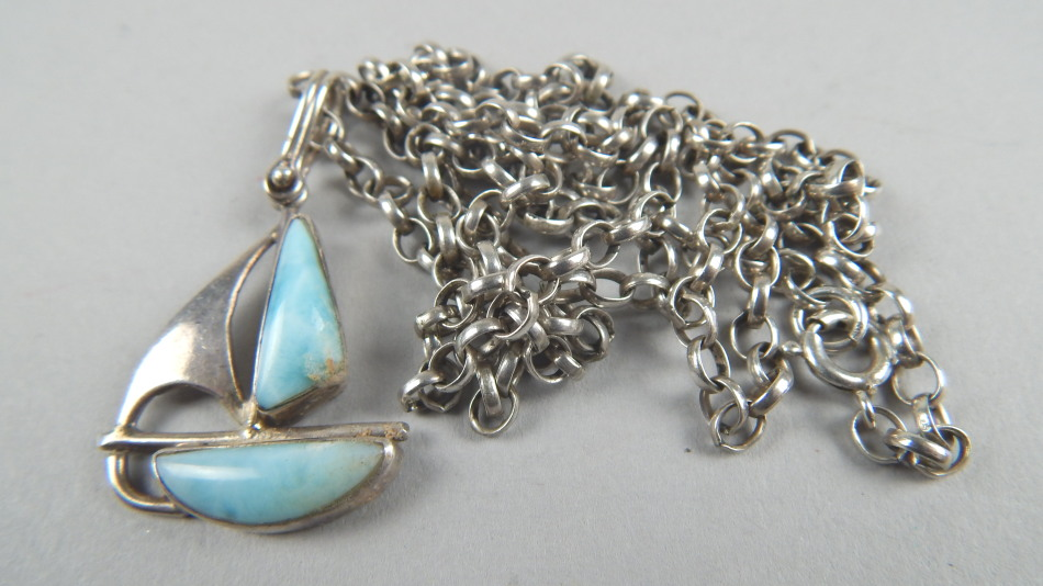 A silver ship pendant and chain the ship stone set