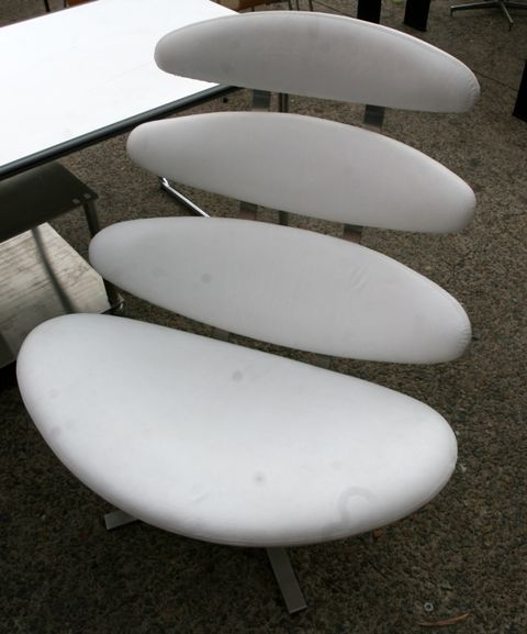 A pair of white leather and aluminium chairs after