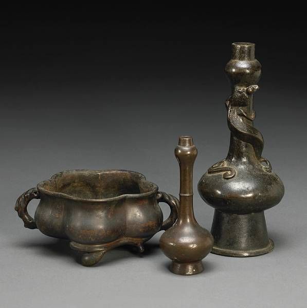 A group of three small cast bronze vessels Including a
