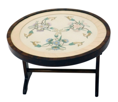 A walnut framed fire screen with embroidered centre on scroll