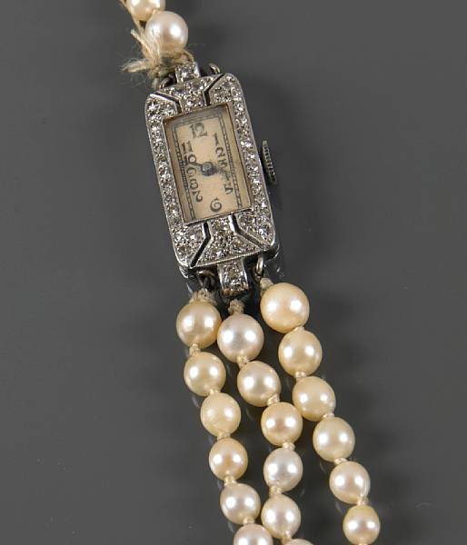A diamond and platinum wrist watch with added cultured pearl