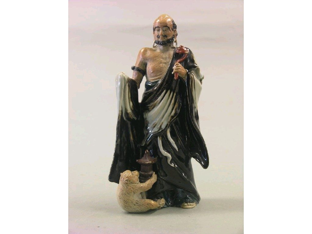 A Thai porcelain figure bearded gentleman a monkey at his