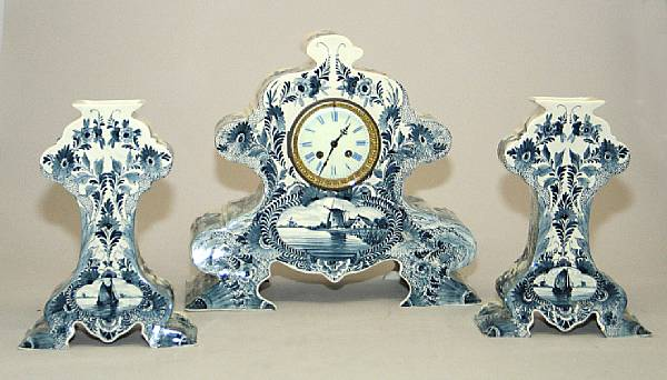 A Dutch Delft blue and white three piece clock garniture