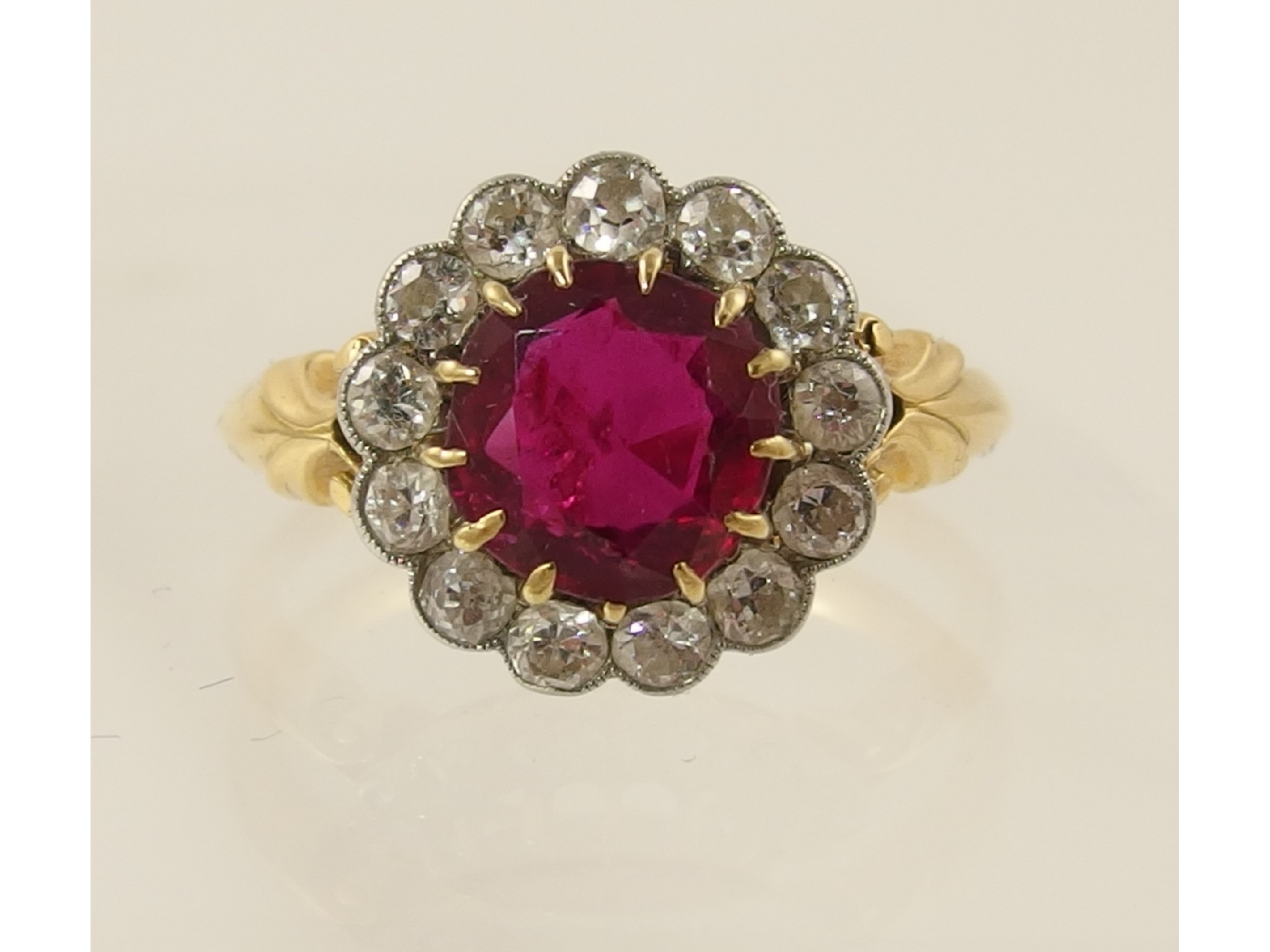 A yellow metal diamond and red gem set ring Diamonds