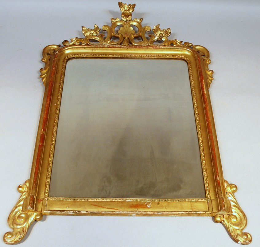 A 19thC gilt wood mirror the shaped glass held with
