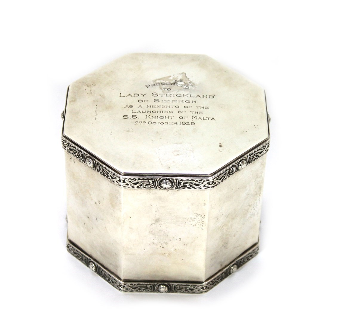 A silver octagonal hinge lidded biscuit barrel decorated with cast