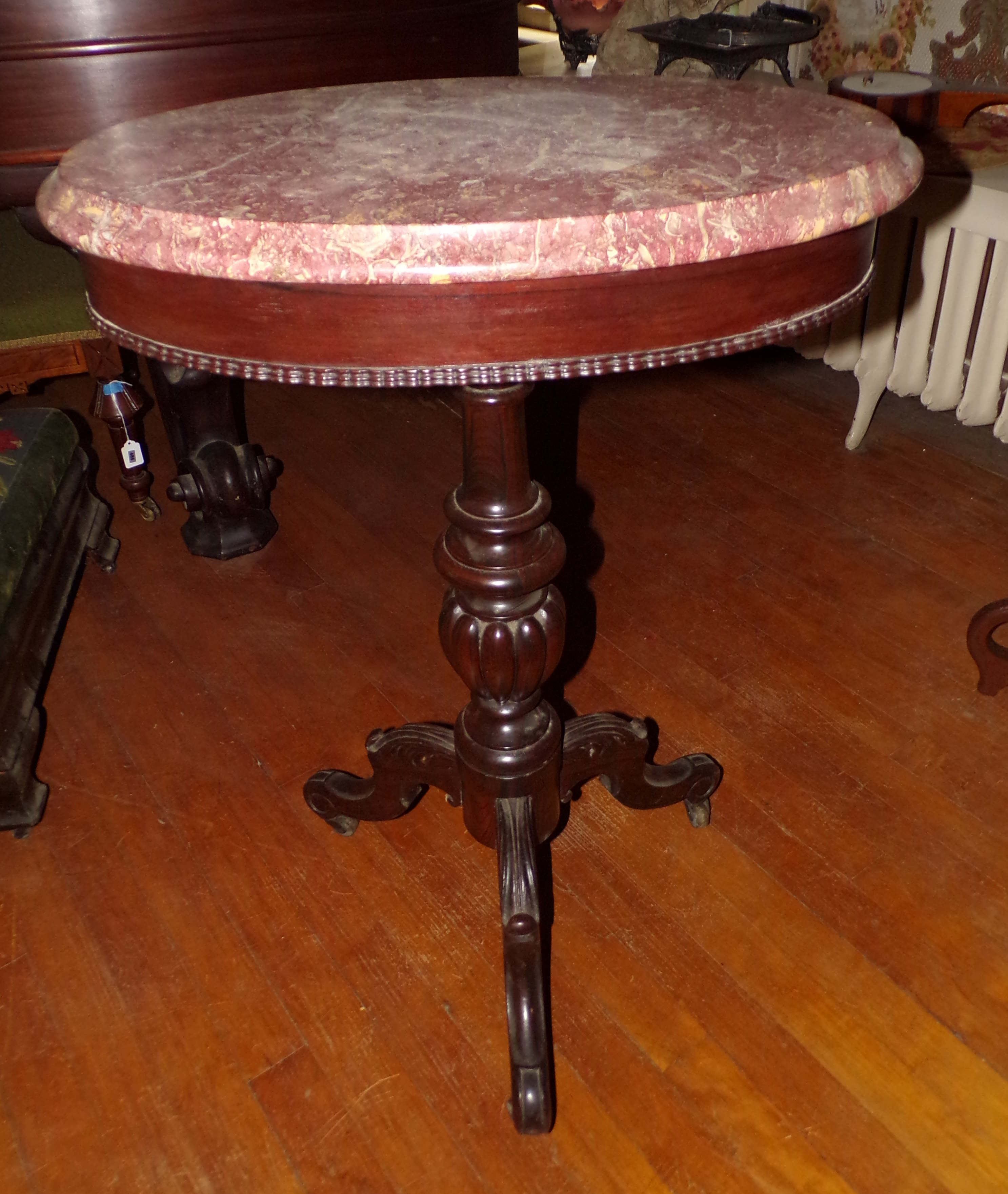 Pink fossilized marble top occasional table turned column support terminating