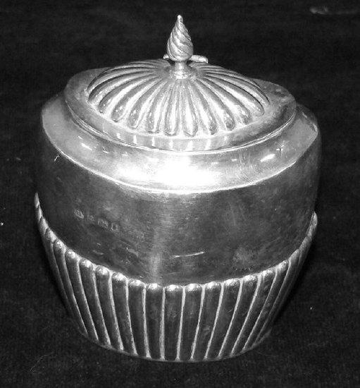 An oval half ribbed tea caddy with hinged cover and