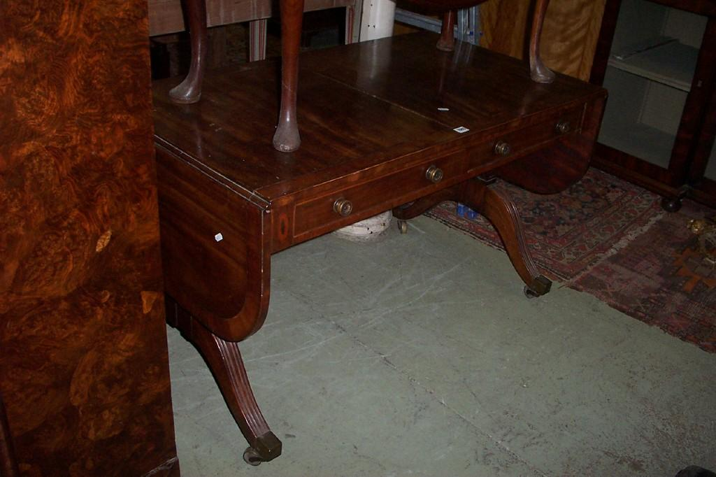An early 19th century mahogany sofa table fall flaps fitted