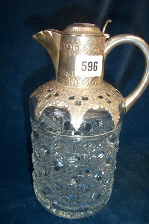 A cut glass decanter of cylindrical form with embossed silver
