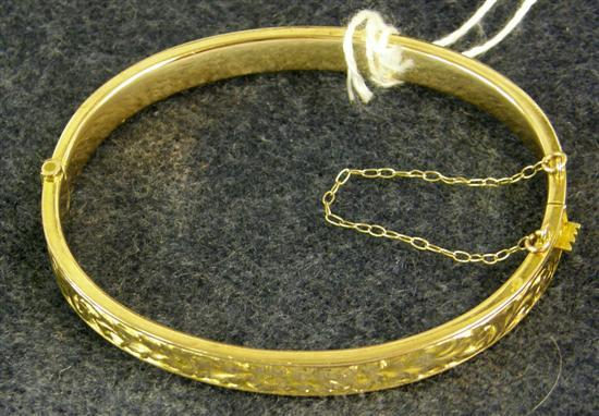 AN EDWARDIAN GOLD HINGED BANGLE with engraved decoration Chester 1910