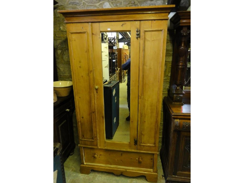 A Victorian stripped pine wardrobe enclosed by a single mirror