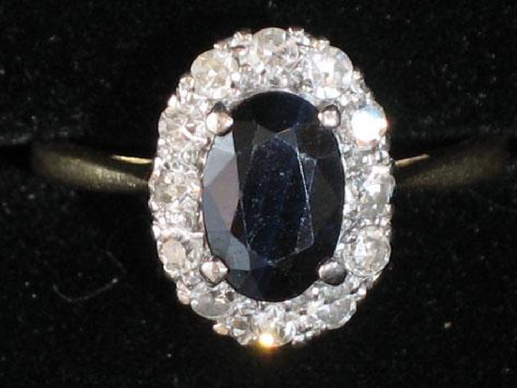A SAPPHIRE AND DIAMOND CLUSTER RING the central oval cushion