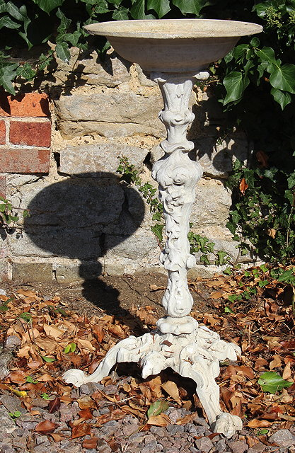 A CAST IRON BIRD BATH with three scrolling feet 34cm
