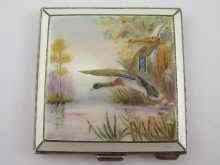 A silver compact engine turned the lid with enamel of