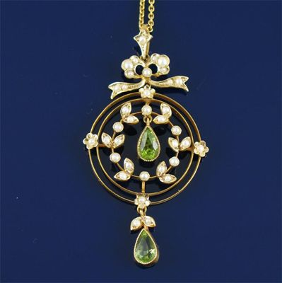 An Edwardian gold pendant set with seed pearls and peridots