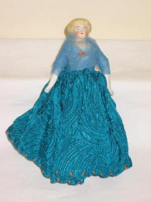 A bisque shoulder head pin cushion doll with painted and