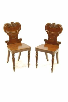 A pair of Victorian mahogany hall chairs with a leaf