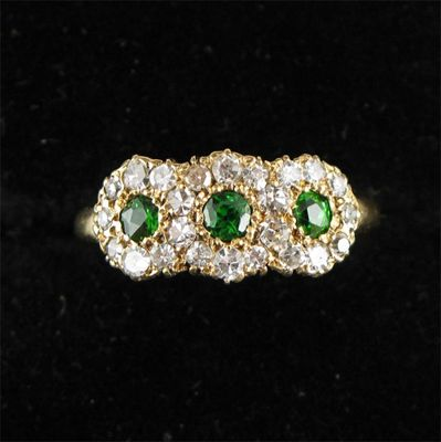 A triple demantoid garnet and diamond cluster ring Set in