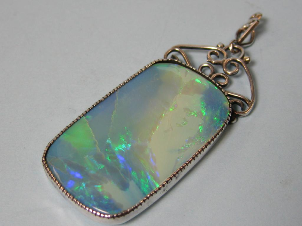 A large oblong Pendant set opal with silver surround having