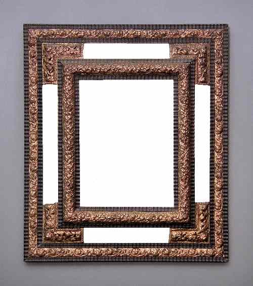 An ebonised and repousse gilt metal framed rectangular wall mirror