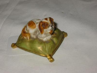 A ROYAL WORCESTER PORCELAIN SPANIEL modelled recumbent on a green