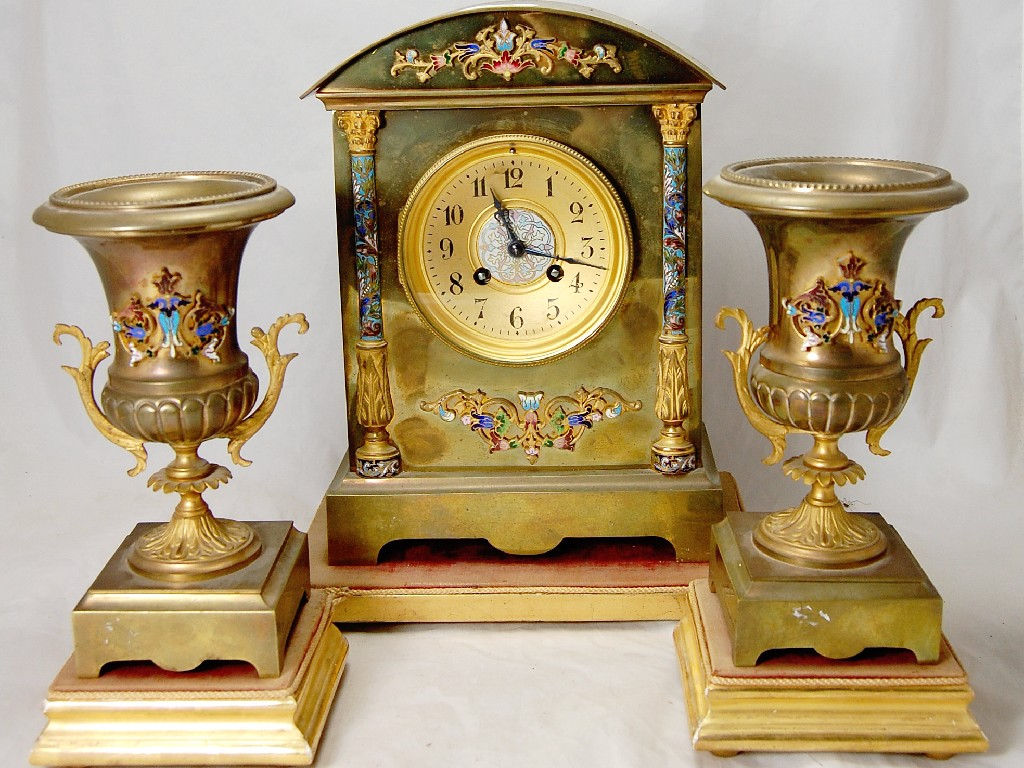 A French clock garniture enamel decorated brass cased with drum