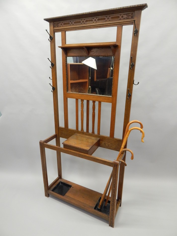 An early 20thC oak hall stand with a central mirror