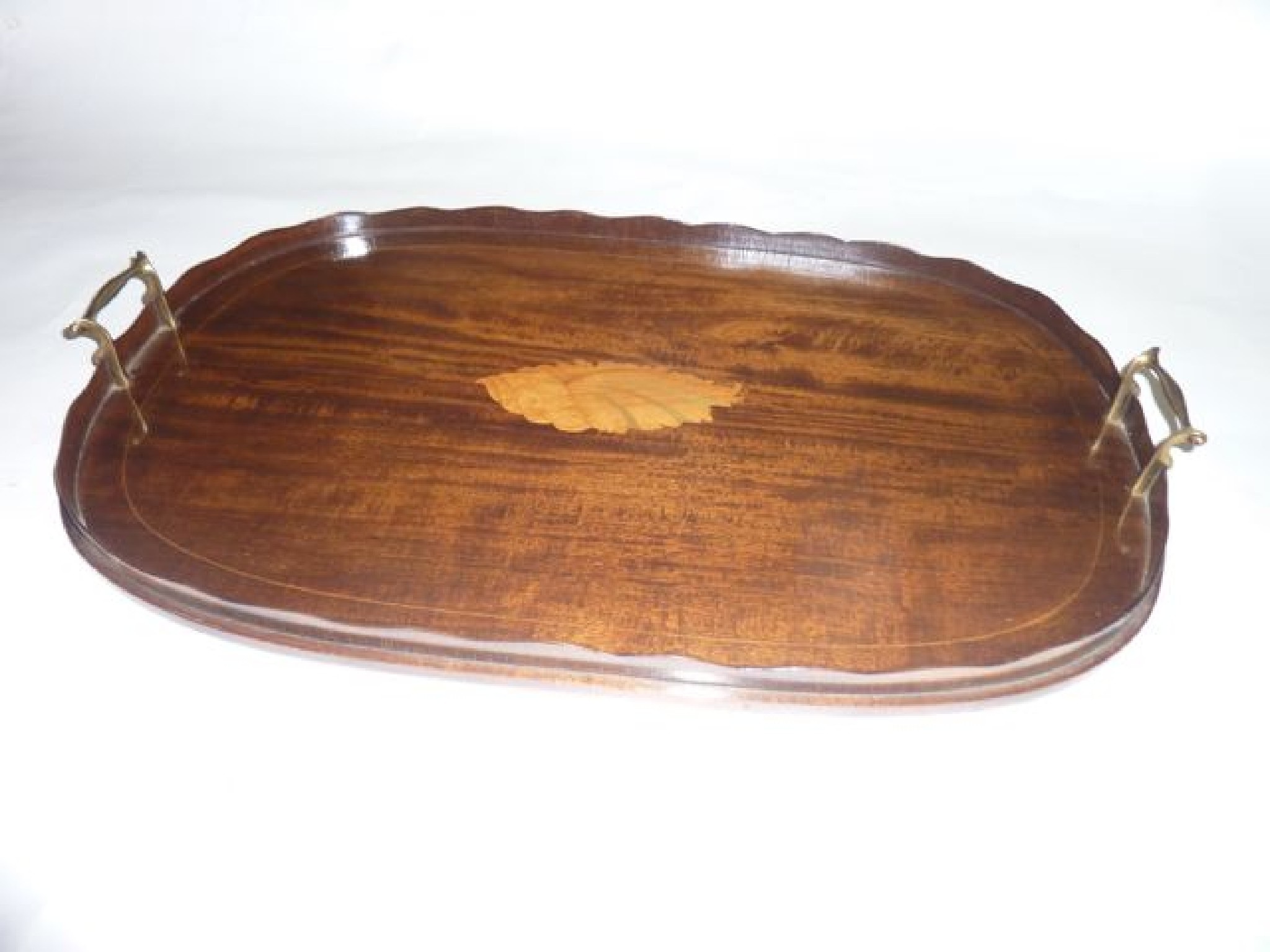 An Edwardian mahogany tray of oval form with shaped gallery