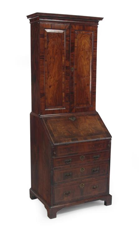 An early 18th century walnut and crossbanded bureau cabinet the