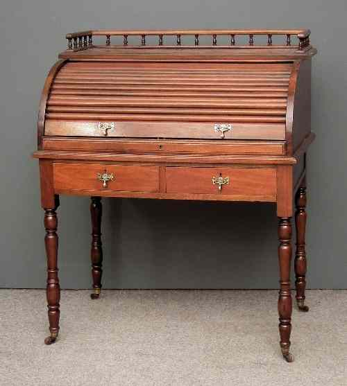 A late Victorian walnut cylinder topped desk the tambour shutter