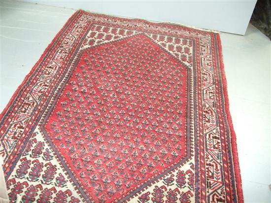 Persian red ground rug with a main cream ground border