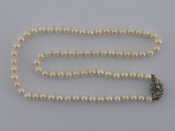A cultured pearl necklace with a white metal tests 18