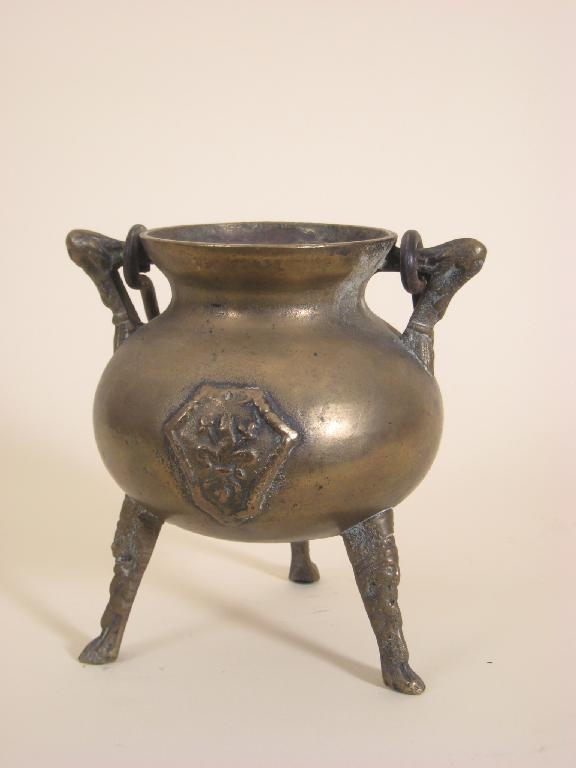 An early bronze Cauldron with swing handle raised cartouche on