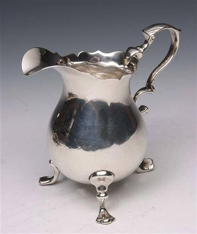 A GEORGE II SILVER CREAM JUG with wavy edge double