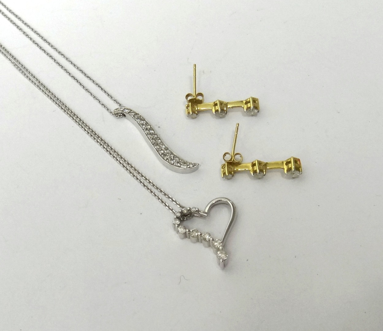 A pair of gold and diamond set three stone earrings